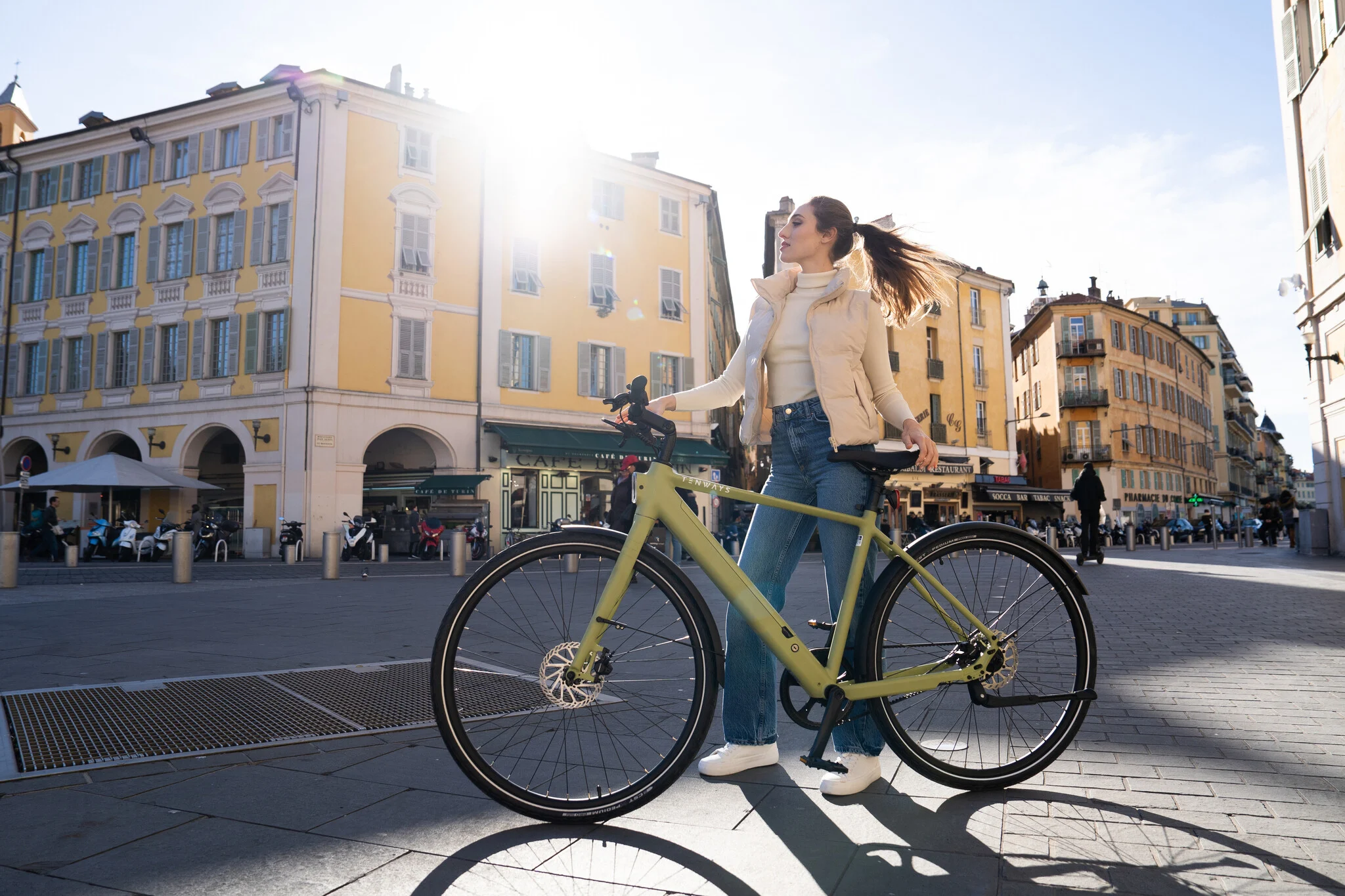 Woman riding a Tenways CGO600 Pro e-bike through a city center, enjoying a smooth and effortless ride